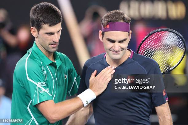 Serbia's Novak Djokovic pats Switzerland's Roger Federer after his victory during their men's singles semi-final match on day eleven of the...