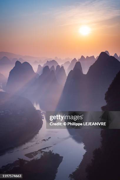 mountain landscape in the mist at dawn with li river in xingping - guilin stock pictures, royalty-free photos & images