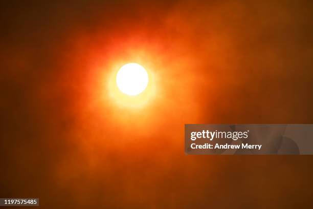 close up of sun through smoke cloud from bush fire with red glow, climate change in australia - miraggio foto e immagini stock