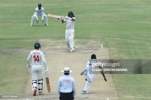 Zimbabwe's Sikandar Raza plays a shot delivered by Sri Lanka's Vishwa Fernando as Zimbabwe's captain Sean Williams and Sri Lanka's Niroshan Dickwella...