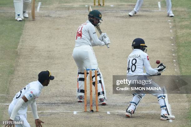 Zimbabwe's captain Sean Williams watches the ball while Sri Lanka's Niroshan Dickwella tries to catch the ball as Sri Lanka's Lasith Embuldeniya...