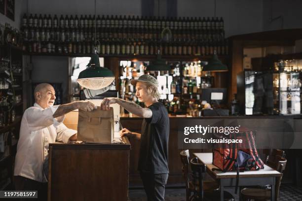 persona di consegna che riceve l'ordine in un ristorante - fast food restaurant foto e immagini stock