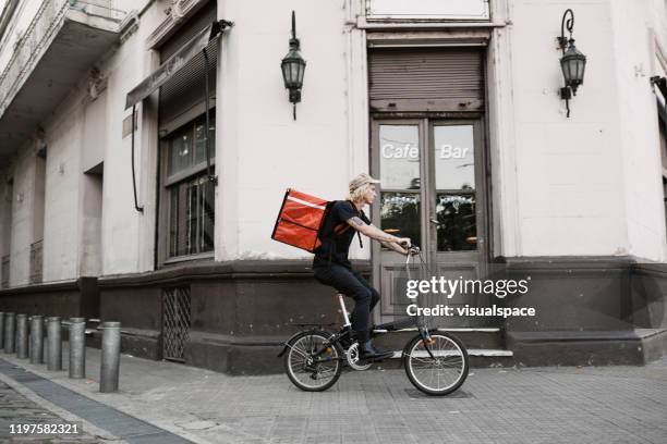 food courier cycling in the city - buenos aires food stock pictures, royalty-free photos & images