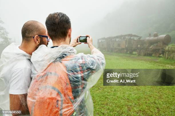 het fotograferen van verlaten treinstation - rain poncho stockfoto's en -beelden