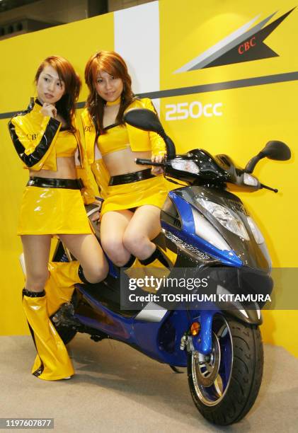 Promotion girls show off Chinese motorcycle maker CBC's "Kylin 250" scooter during the 33th Tokyo Motorcycle Show 2006 in Tokyo, 02 April 2006. A...