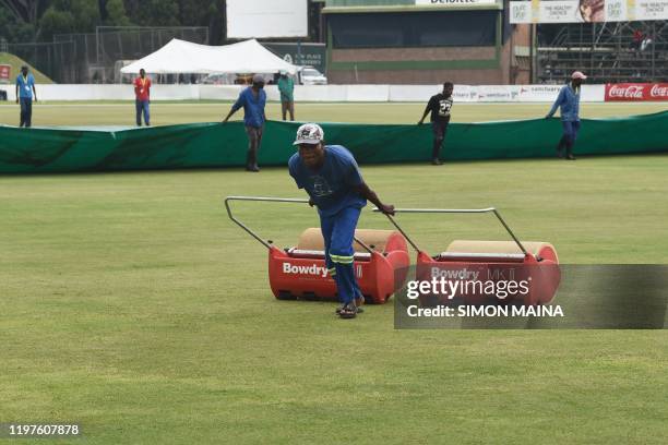 Groundsman drags a roller towards the pitch while a cover is dragged onto the field to cover the pitch as rain has delayed play during the fourth day...