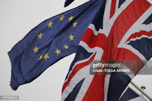 An EU Flag flown by an anti-Brexit protester is seen with a Union Flag set on a flag pole in Parliament sq1uare in front of the Houses of Parliament...