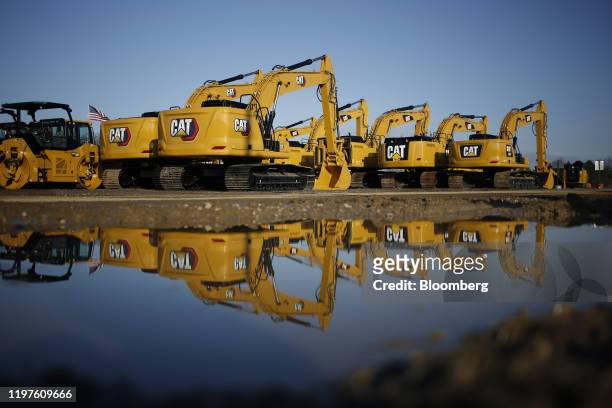 Caterpillar Inc. Excavators are reflected in a puddle at the Whayne Supply Co. Dealership in Louisville, Kentucky, U.S., on Monday, Jan. 27, 2020....