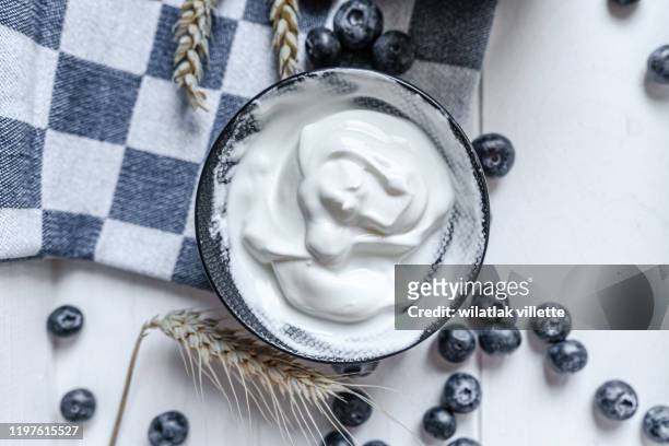yogurt in bowl on wooden table. healthy eating - dairy farm stock-fotos und bilder