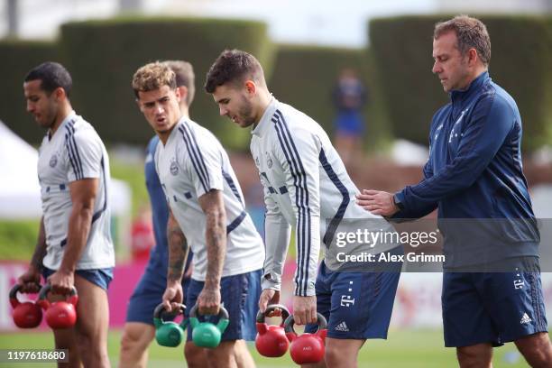 Head coach Hansi Flick helps Thomas Mueller during a training session at Aspire Zone during day two of the FC Bayern Muenchen winter training camp on...