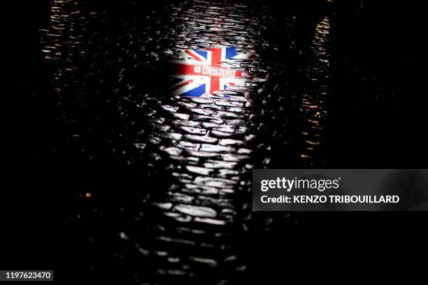 Picture taken on January 30, 2020 shows the reflection of a Union Jack flag on the ground during an event to celebrate the friendship between Belgium...