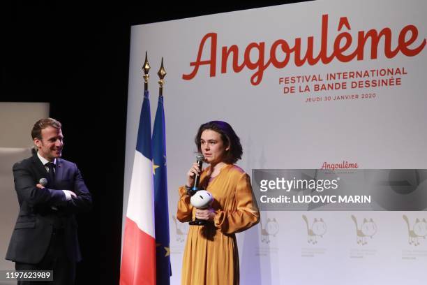 French President Emmanuel Macron looks on as French comic books author Adele Maury gives a speech after receiving the "Prix du Jeune Talent" award...