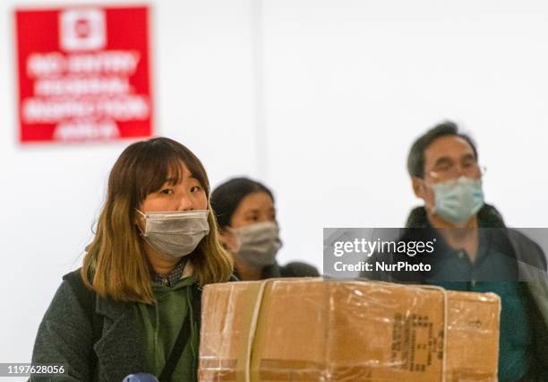 Passengers wearing face masks walk out of the international terminal at the San Francisco International Airport in Millbrae, California, United...