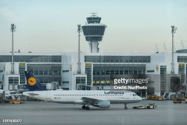 Lufthansa Airbus A320 with registration D-AIZF in front of the terminal and control tower of Munich Airport. Early morning airplane traffic movement...