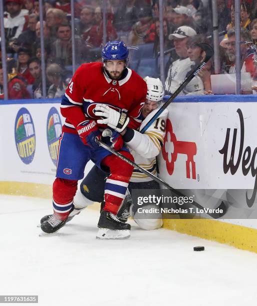 Phillip Danault of the Montreal Canadiens finishes his check on Jake McCabe of the Buffalo Sabres behind the Buffalo net during the first period of...