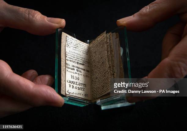 Principal curator Ann Dinsdale holds a rare 600,000 'little book' written by Charlotte Bronte following its return home to the Bronte Parsonage...