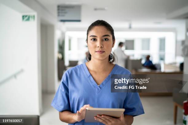 porträtt av kvinnlig sjuksköterska använda tablett på sjukhus - medical scrubs bildbanksfoton och bilder
