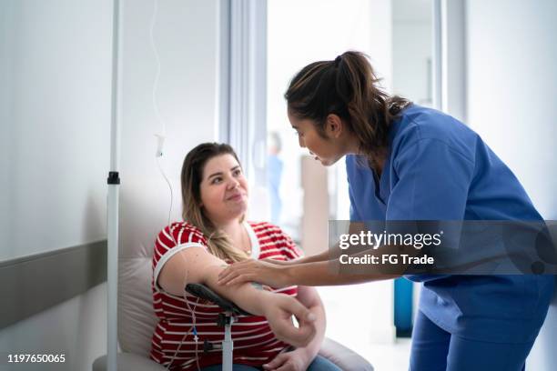 mulheres recebem tratamento de gotejamento intravenoso - enfermeira - fotografias e filmes do acervo