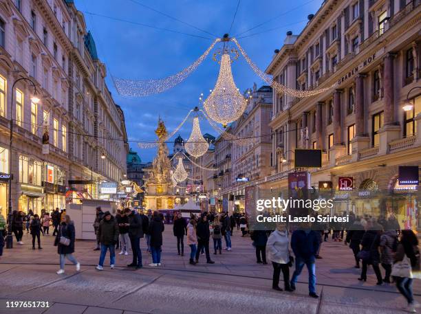 Tourists walk around the Plague Column at the Graben street on December 30, 2019 in Vienna, Austria.