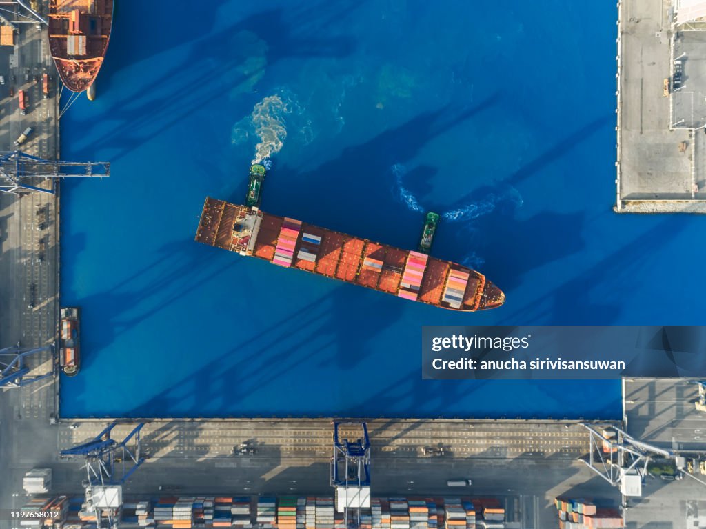 Aerial top view crane car lifting container in warehouse.