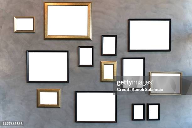 blank picture frames hanging on cement wall - picture frames on wall stock pictures, royalty-free photos & images