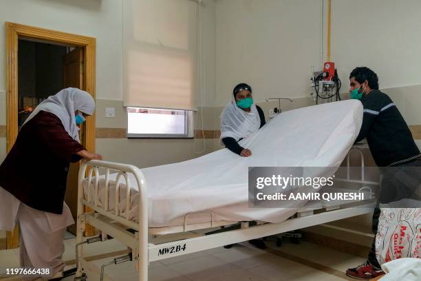 Medical staff members wearing protective masks prepare a room in an isolation ward as a preventative measure following the coronavirus outbreak, at...