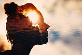 Sun peeks out from behind the clouds in woman's head
