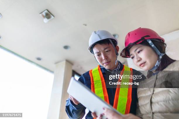 junge bauunternehmerin erklärt männlichen bauarbeitern arbeiten - quality control inspectors stock-fotos und bilder