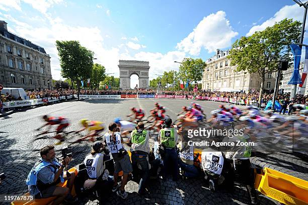 Cadel Evans of BMC Racing Team and the peloton pass photographers positioned near the Arc de Triomphe during Stage 21 of the Tour de France between...