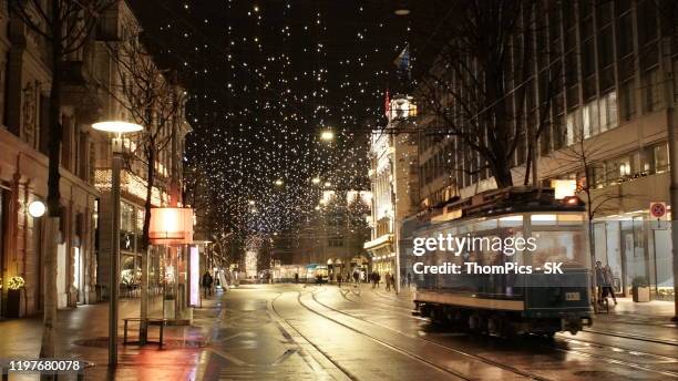 zurich bahnhofstrasse at night with vintage tram and holiday christmas lighting. - zurich christmas stock pictures, royalty-free photos & images