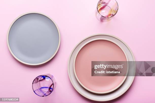 empty plates and drinking glasses on pink background - dish top view stock pictures, royalty-free photos & images