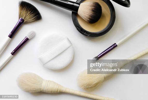 branded cosmetics. mineral compact powder, sponge and various brushes for application, isolated on a white background. selective focus. - powder compact 個照片及圖片檔