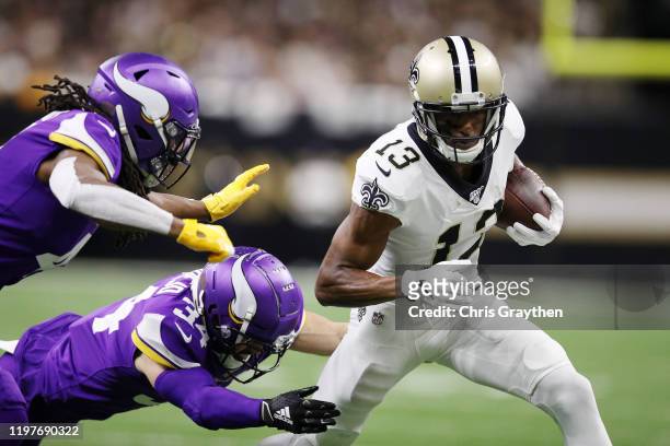 Anthony Harris and Andrew Sendejo of the Minnesota Vikings attempt to tackle Michael Thomas of the New Orleans Saints during the first half in the...
