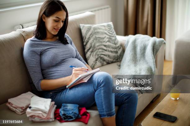 gravid kvinna gör anteckningar - barnafödsel bildbanksfoton och bilder