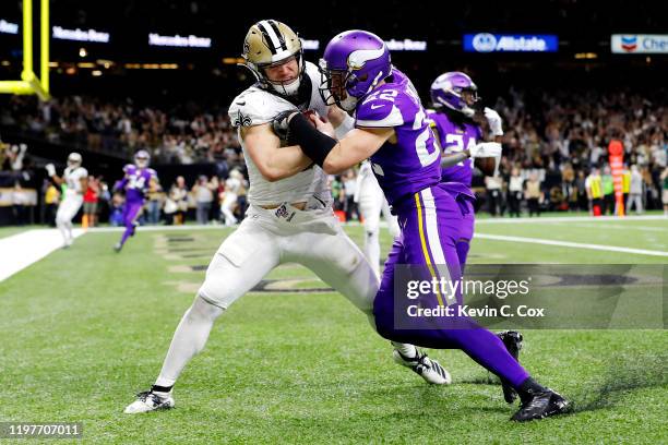 Taysom Hill of the New Orleans Saints scores a 20-yard receiving touchdown during the fourth quarter as he is defended by Harrison Smith of the...