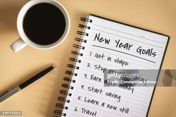 new year goals written on notebook - goede voornemens stockfoto's en -beelden