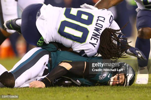 Quarterback Carson Wentz of the Philadelphia Eagles is hit by Jadeveon Clowney of the Seattle Seahawks during the NFC Wild Card Playoff game at...