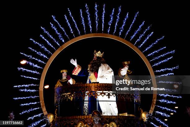 Performer dressed as Gaspar King waves his hand to the public as he rides a float during the 'Cabalgata de Reyes,' or the Three Kings paradeon...