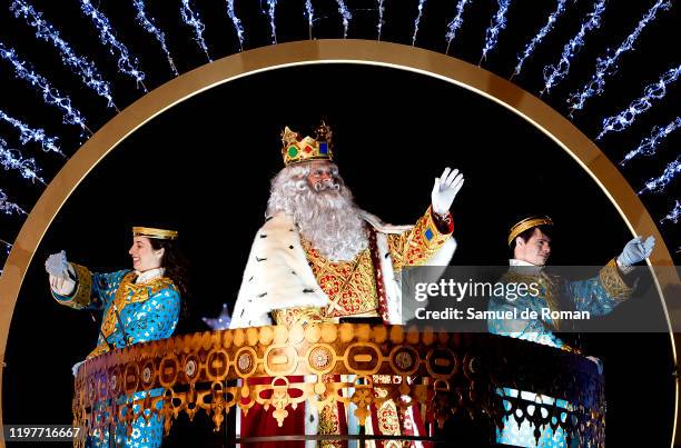 Performer dressed as Melchoir King waves his hand to the public as he rides a float during the 'Cabalgata de Reyes,' or the Three Kings paradeon...