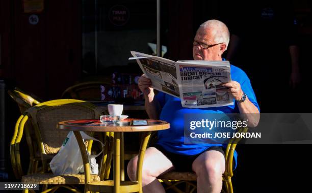 Briton reads a newspaper in Benidorm on January 31, 2020. - On the sun-drenched eastern coast of Spain, British retirees, workers and small business...