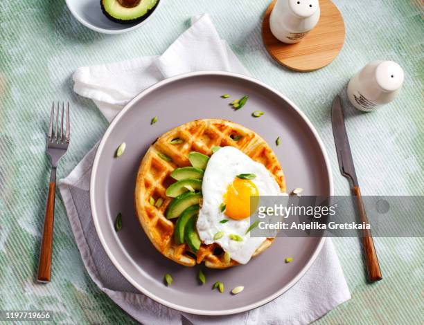savory waffles, fried eggs and avocado for delicious healthy breakfast - waffles stock pictures, royalty-free photos & images