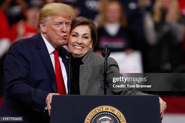 President Donald Trump gives a kiss on the cheek to Iowa Governor Kim Reynolds during a campaign rally inside of the Knapp Center arena at Drake...