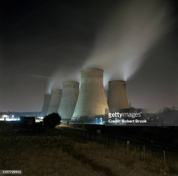 fossil fuel power station at night - paris agreement stock pictures, royalty-free photos & images