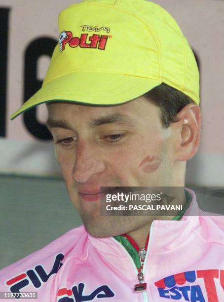 L'Italien Ivan Gotti, dont la joue porte la trace de rouge à lèvres, semble pensi, le 05 juin 1999 sur le podium à Aprica, à l'issue de la 21e étape...