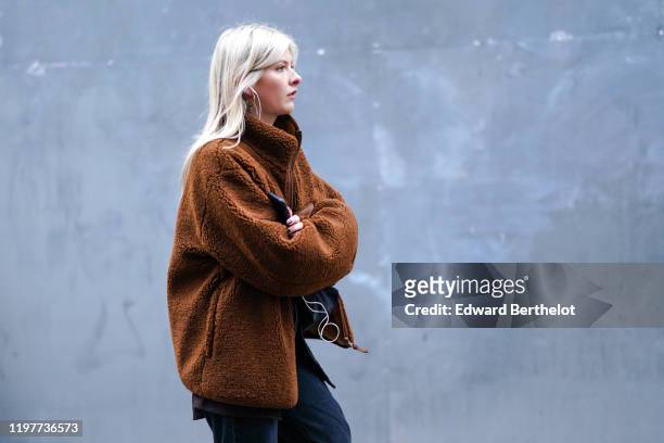 Guest wears a brown fluffy winter coat, during London Fashion Week Men's January 2020 on January 05, 2020 in London, England.