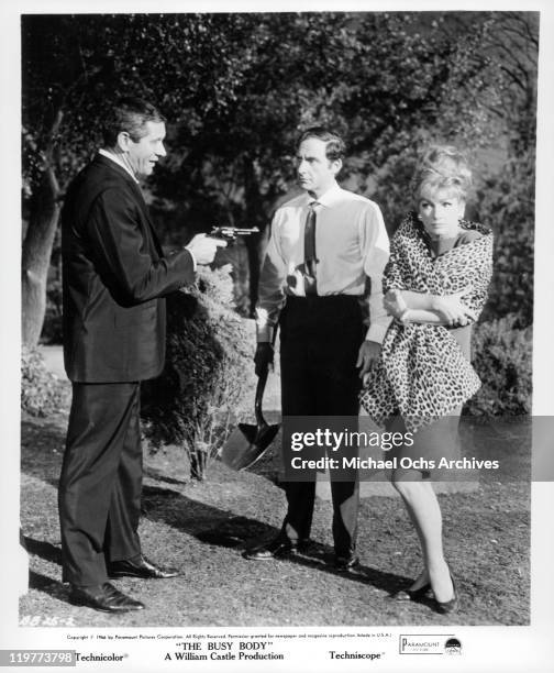 Jan Murray points gun at Sid Caesar while Anne Baxter freezes in a scene from the film 'The Busy Body', 1966.