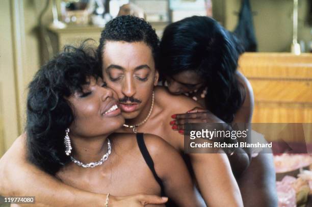Goldy, played by Gregory Hines , enjoys the attentions of two ladies in a brothel scene from 'A Rage in Harlem', directed by Bill Duke, 1991.