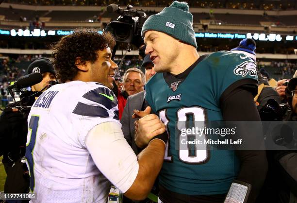 Quarterbacks Russell Wilson of the Seattle Seahawks and Josh McCown of the Philadelphia Eagles shake hands after the Seahawks win the NFC Wild Card...