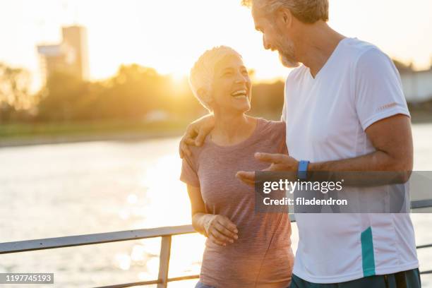 senior paar ontspannen na het joggen - engaged sunset stockfoto's en -beelden