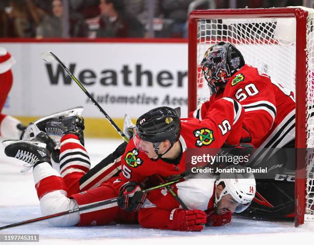 Connor Murphy of the Chicago Blackhawks lands on top of Robby Fabbri of the Detroit Red Wings as they slide into Corey Crawford at the United Center...